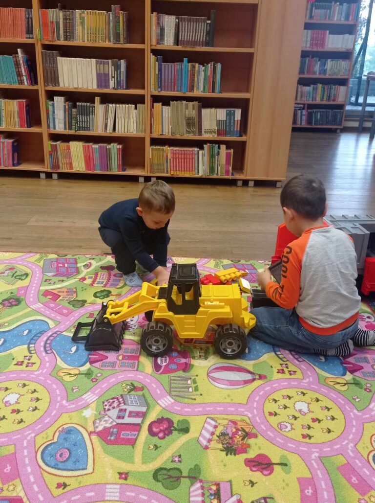 Dzieci bawiące się żółtym samochodem.