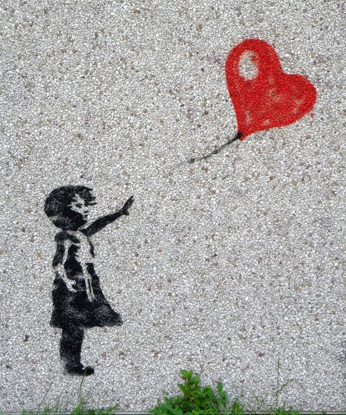 Mural przedstawiający dziewczynkę, która wypuszcza czerwony balon w kształcie serca